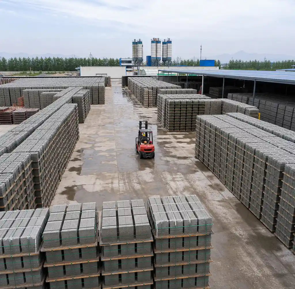 Block curing area showing systematic pallet stacking and inventory management for QT10-15 production