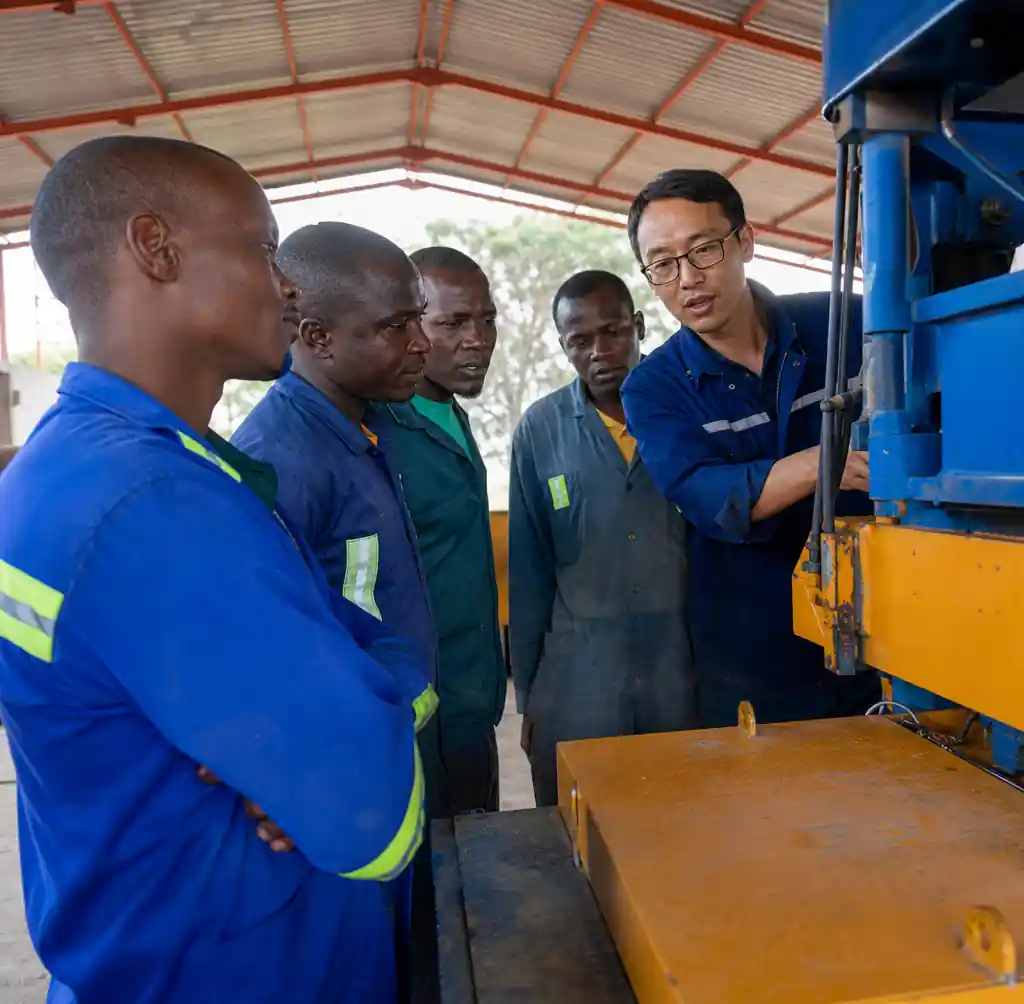 Chinese technician training African workers on block machine operation and maintenance